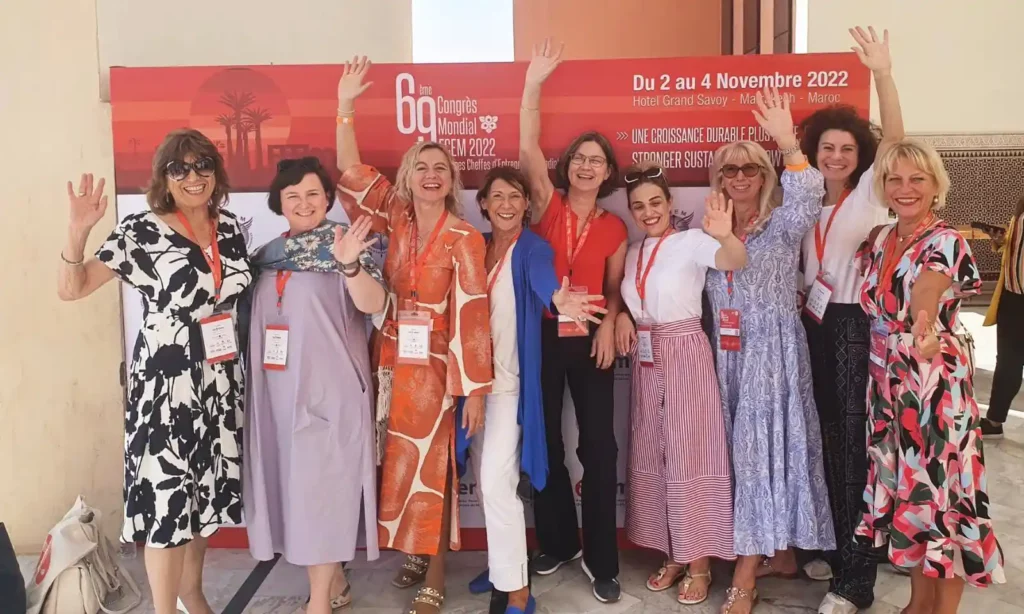 Elegante Geschäftsfrau steht selbstbewusst zwischen moderner Skyline und asiatischer Architektur – Symbol für interkulturellen Erfolg.